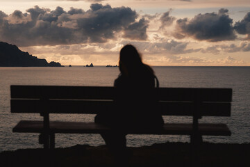 A peaceful silhouette sits on the iconic bench at Loiba Cliffs, overlooking the vast Atlantic Ocean.