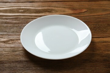 Empty round plate on wooden background, top view