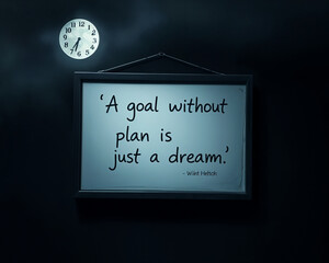 Motivational Quote About Planning for Goals in Dark Setting. A motivational quote, "A goal without a plan is just a dream," displayed on a framed whiteboard, hanging against a dark backdrop.