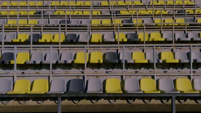 The seating in the empty stadium features an interesting combination of yellow and gray chairs