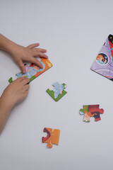 children's hands putting together a puzzle