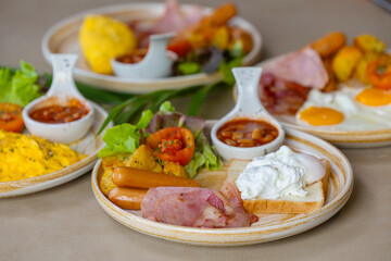 Breakfast with fried eggs and bacon and sausage. Breakfast set at hotel. Hearty Traditional Breakfast Plate with Eggs, Sausage, Bacon, Toast, and Vegetable Salad.