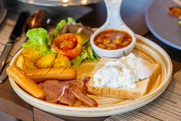 Breakfast with fried eggs and bacon and sausage. Breakfast set at hotel. Hearty Traditional Breakfast Plate with Eggs, Sausage, Bacon, Toast, and Vegetable Salad.