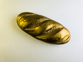 Golden loaf. Piggy bank in the form of a bread loaf on a white background. Top view