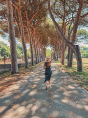 Fototapeta premium Through the Trees: A Timeless Summer Moment, Young Woman with a Hat