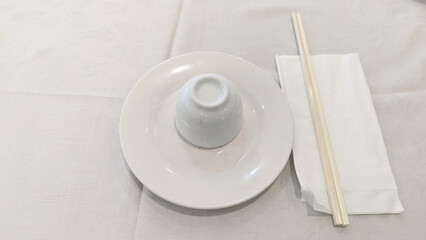 Photo of green tea place setting with chopsticks, napkin, and tableware tradition, hospitality, celebration, Chinese culture. Concept of Chinese new year, lunar year, dim sum, green tea, dining.