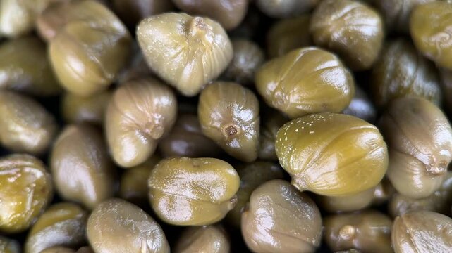 Pickled marinated green capers top view, rotation