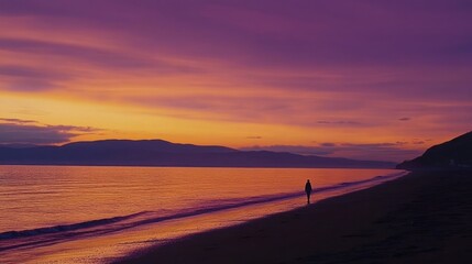 Obraz premium Solitary Sunset Stroll: A Serene Coastal Scene at Dusk