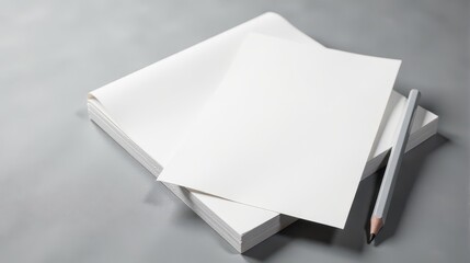 Minimalist workspace with blank sheets of paper and a pencil on a sleek gray surface, ideal for creativity and planning