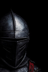 Historical knight in weathered armor standing against a dark backdrop with dramatic lighting effects. Generative AI