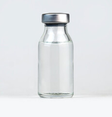 Simple glass vial with a metal cap filled with a clear liquid