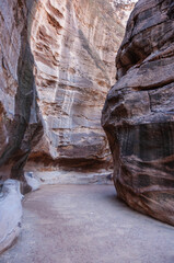 A narrow canyon with a large rock wall on either side