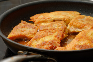 Frying breaded carp fish on cooking pan