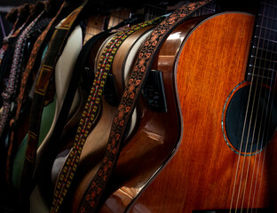 Guitars - many acoustic, bass and electric guitars on guitar rack stand backstage at a live music...