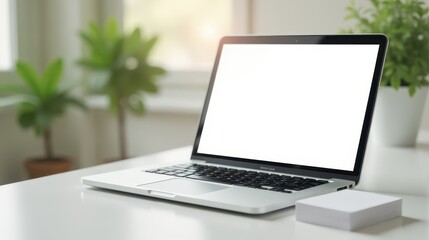 Fototapeta premium A laptop with a blank screen sits on a white desk surrounded by green potted plants and notebooks, creating a serene workspace by the window