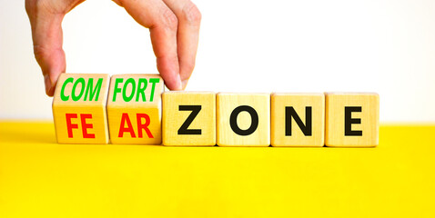 Comfort or fear zone symbol. Concept words Comfort zone Fear zone on wooden cubes. Beautiful yellow table white background. Psychologist hand. Business and comfort or fear zone concept. Copy space.