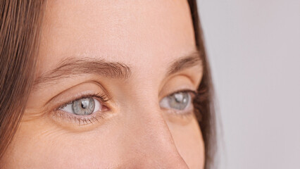 Laser eye surgery. Extreme close up macro shot of eyes female millennial looking away, advertising...