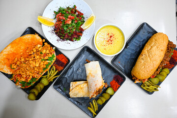 Delicious meat kebab with fresh vegetable salad served with variety of Turkish dishes and appetizers. Top view of assorted Turkish food and meze, tasty and healthy Mediterranean cuisine.