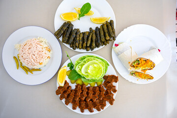 Delicious meat kebab with fresh vegetable salad served with variety of Turkish dishes and appetizers. Top view of assorted Turkish food and meze, tasty and healthy Mediterranean cuisine.