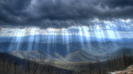 Scenic mountain landscape with dramatic clouds and sun rays.
