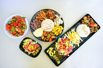 Delicious meat kebab with fresh vegetable salad served with variety of Turkish dishes and appetizers. Top view of assorted Turkish food and meze, tasty and healthy Mediterranean cuisine.