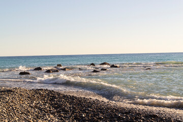 Teal sea wave crashing near a rocky shore, sea storm background