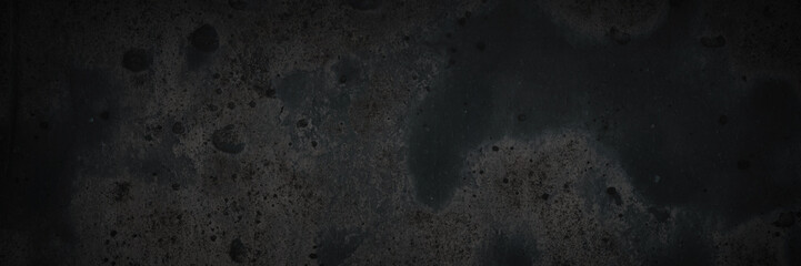 Texture of the old wall. Rough grungy surface of painted plastered concrete wall with spots, cracks, noise and grain. Dark wide panoramic background for design. Shaded vintage texture with vignette.