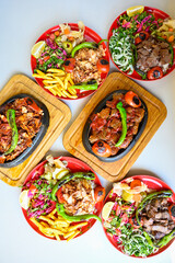 Delicious meat kebab with fresh vegetable salad served with variety of Turkish dishes and appetizers. Top view of assorted Turkish food and meze, tasty and healthy Mediterranean cuisine.