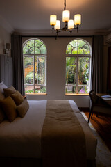 View of tropical garden from inside a luxury hotel room, king bed and desk and chair, Nairobi, Kenya
