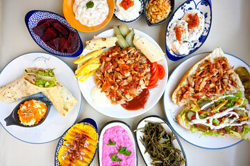 Delicious meat kebab with fresh vegetable salad served with variety of Turkish dishes and appetizers. Top view of assorted Turkish food and meze, tasty and healthy Mediterranean cuisine.