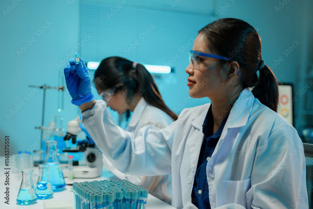 Wall mural scientists working with test tubes and microscope doing experiments and research in a laboratory