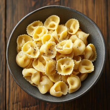 Yellow torti pasta flatlay in a grey bowl.