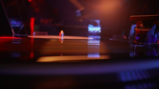 Classic Vinyl Record Playing With neon light at night. Macro. Turntable spin, LP