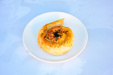 Turkish style meat stuffed filo dough borek served kol boregi.Cheese and minced pie are sliced on a marble background. Turkish name: Kol Boregi, kiymali, peynirli su boregi. Ci borek. Kafkas cig borek