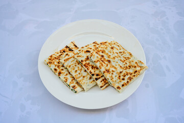 Freshly baked appetizing Turkish tortillas - Gozleme with spinach, cheese  on a wooden board. Space for text. Shallow depth of  field. Handmade traditional  Patatesli, Ispanakli, peynirli gozleme.