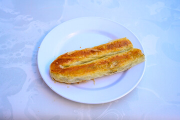 Turkish style meat stuffed filo dough borek served kol boregi.Cheese and minced pie are sliced on a marble background. Turkish name: Kol Boregi, kiymali, peynirli su boregi. Ci borek. Kafkas cig borek