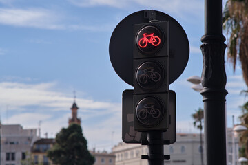 On the street there is a traffic light with the image of a bicycle