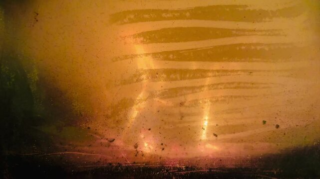 fuoco di legna che arde nel braciere di una vecchia stufa visto attraverso un vetro sporco di fuliggine