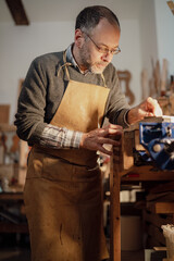 Italian violin maker crafting violin in cremona workshop