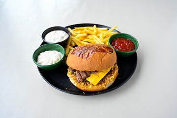 Big tasty burger with beef cutlet on a plate. Hamburger, cheeseburger with mushroom. Hamburger, Mexica, mushroom double burger.  Crispy chicken burger. With french fries, patates kizartmasi.
