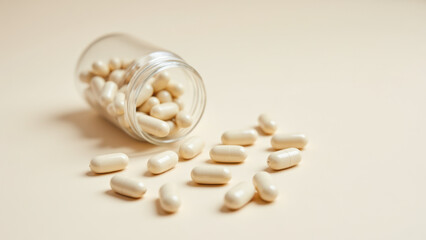 Magnesium glycinate supplement capsules spilled from a bottle onto a table.