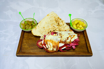 Close-up shot of Izmir's famous Turkish Traditional Kumru Sandwich, Ceşme Kumru, patso ingredients ready to eat salami, soudjouk, tomato, cheddar cheese and fried cheese. Yengen sandvic.