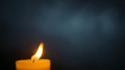 Single blurred candle in a dark background