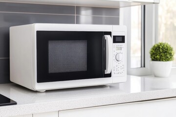 Obraz premium A sleek white microwave oven on a modern kitchen countertop, perfect for quick meals and snacks.