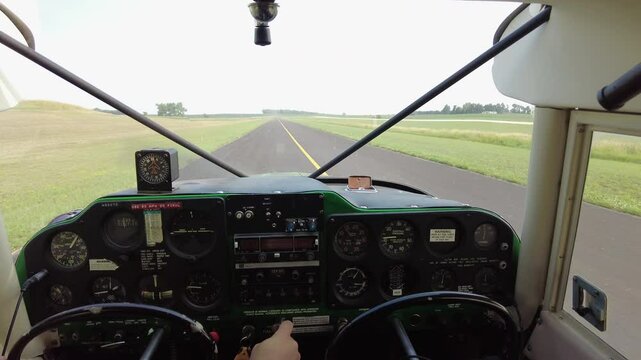 View from inside a vintage Piper aircraft as the pilot taxis it down the runway.