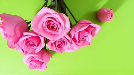 A bouquet of pink roses is displayed on a green background.