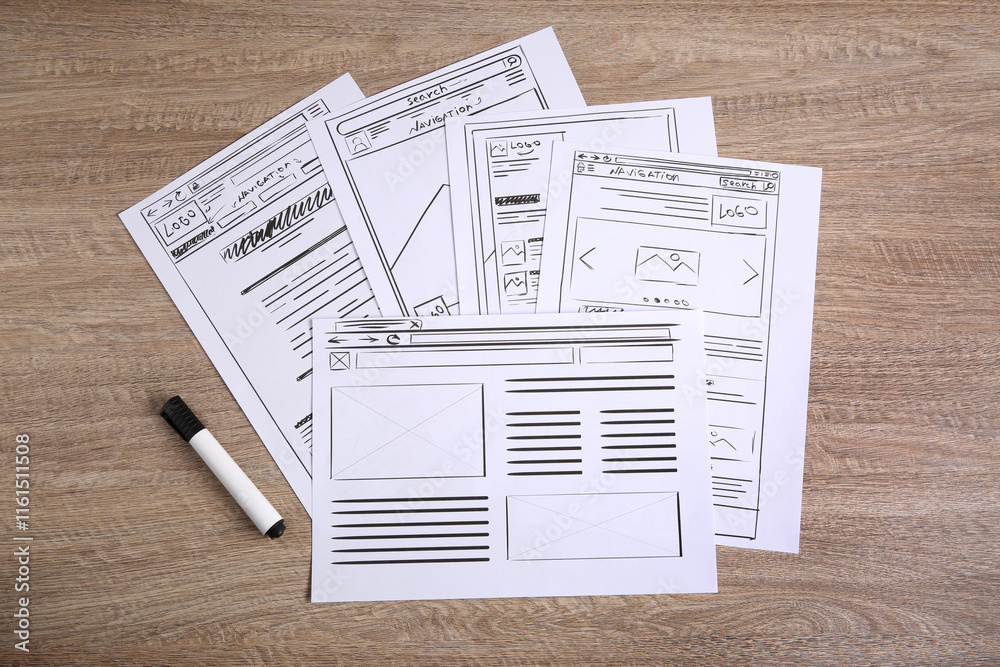 Wall mural developing ui design. sketches of website wireframes and felt pen on wooden table, top view