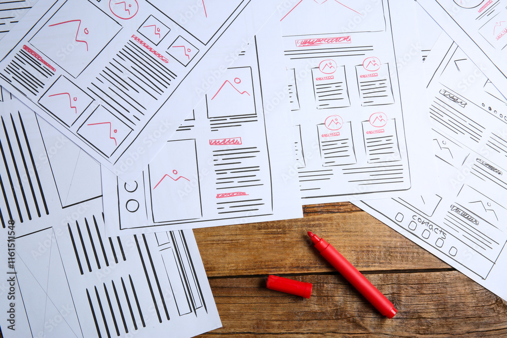 Sticker developing ui design. sketches of website wireframes and felt pen on wooden table, top view