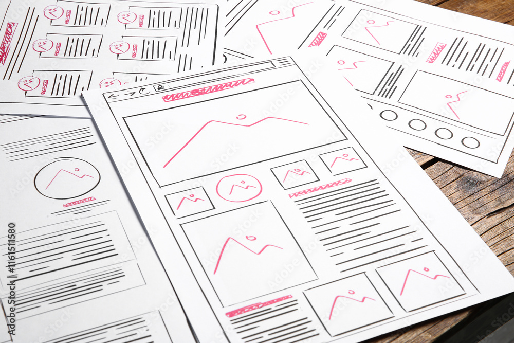 Wall mural developing ui design. sketches of website wireframes on wooden table, closeup