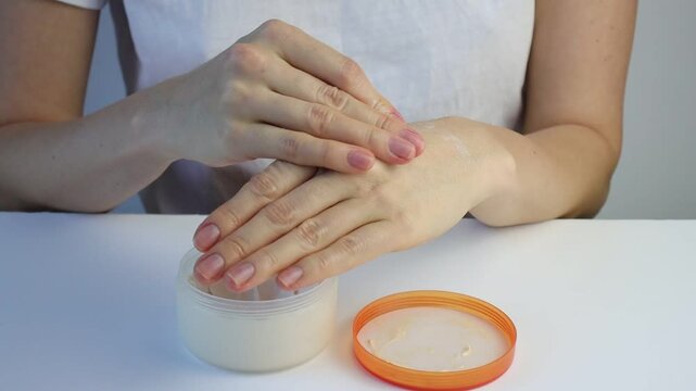White European Girl Applying Hand Cream. Copy Space Close Up